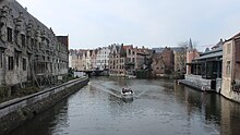 Einer der Genter Kanäle mit einem nahenden typischen Sightseeing-Boot. Rechts der Neubau des alten Fischmarktes