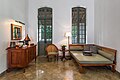 Lobby lounge of Amantaka Suite with armchair and couch, wooden furniture and coffee machine.