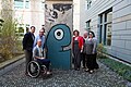 Mallory Weggemann with her family in the yard , with a piece of the Berlin Wall painted by Thierry Noir