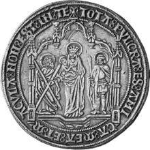 The reverse of a medal struck in 1477 to celebrate the marriage between Mary and Maximilian. The Virgin, with Child in her lap, stands between two Saints. Inscription reads "tota pulc(h)ra es amica mea et macula non est in te", an excerpt from the address to the betrothed woman in the Song of Songs. Likely commissioned by Maximilian as a gift to his own immaculate bride. The obverse show names and coats-of-arms of the couple. Medal-struck-to-commemorate-the-marriage-between-Mary-and-Maximilian-reverse-silver.png