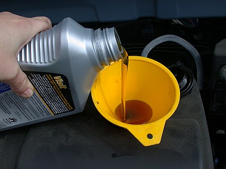 Using a funnel to assist with a motor oil refill