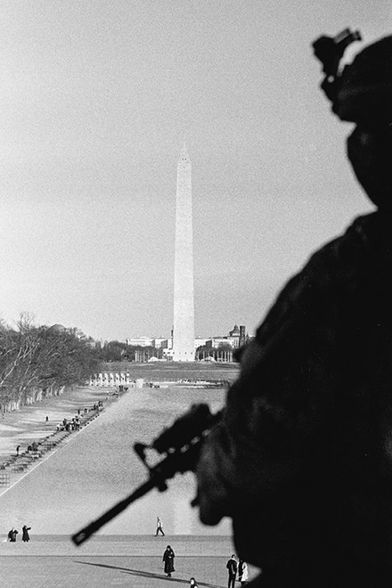 Photograph of a National Guardsman looking over the Washington Monument in Washington D.C. on January 21, 2021