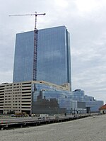 A picture showing a high blue building next to a road