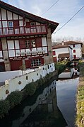 Weerspiegeling van huizen in een beek.