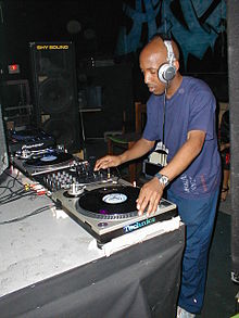 A man with headphones operating a set of two turntables.
