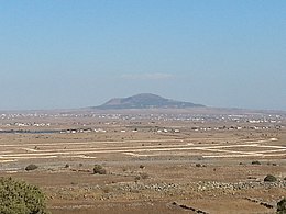 Vulkanski stožec Tell al-Hara v regiji Jaydur na Hauranski planoti, gledan z Golanskega višavja na zahodu