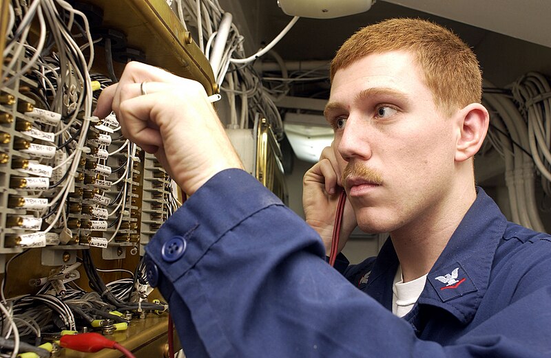 File:US Navy 021230-N-1356A-003 Electronics Technician 3rd Class Jeff Dupont assigned to the Combat Systems Division, performs maintenance on one of the ship's "sailor phone" junction boxes.jpg