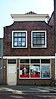 Winkel/woonhuis, twee bouwlagen, bakstenen afgeknotte tuitgevel, gestucte latei, topgevel met rollaag en kroonlijst en een sporenkap uit 1800 (Gouda-Centrum)