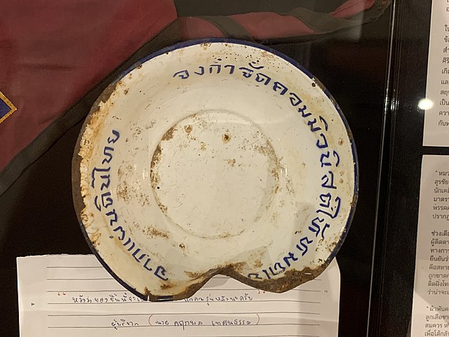 A zinc bowl engraved with Thai message reading "Obliterate all the communists - out of the soil of Thailand" - a propaganda tool against communist ins