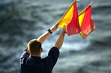 A naval signaler transmitting a message by flag semaphore (2002). 020118-N-6520M-011 Semaphore Flags.jpg