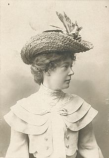 Half-length black and white photo of a woman wearing a straw hat and looking for recbts.