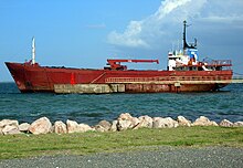 A 30- to 40-year-old general cargo ship anchored off Cap-Haitien, Haiti, before being broken up. Cargo ship ready for scrapping at Cap Haitien.jpg