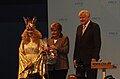 2014年12月にニュルンベルクで開催されたキリスト教社会同盟 (CSU) の大会で、アンゲラ・メルケル首相とホルスト・ゼーホーファーバイエルン州首相に贈り物を渡すクリストキント役の女性
