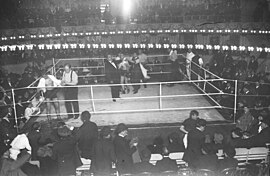 Un ring de boxeo levantado sobre la pista de circo. El combate está pausado por el árbitro.