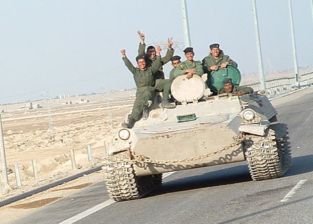 Iraqi military men riding on tank.jpg