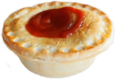A typical Australian meat pie with tomato sauce