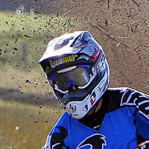 A motocross helmet showing the elongated visor and chin bar