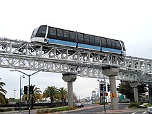 A BART Cable Liner people mover at Oakland Airport Oakland Airport Connector cable car crossing Airport Access Road, March 2018.JPG