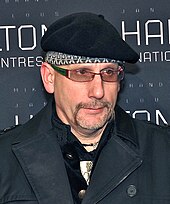 A picture of a man wearing a black jacket and hat