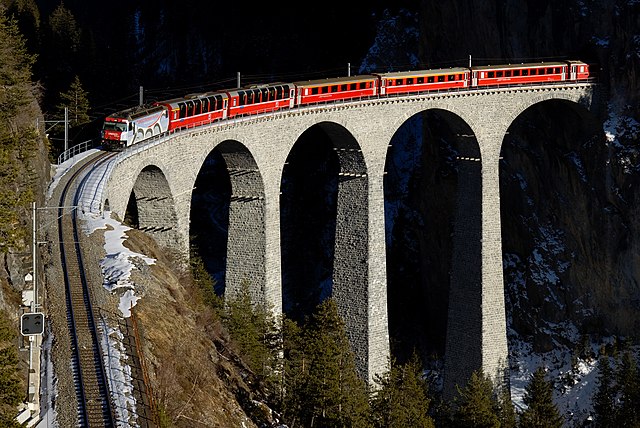 Электровоз Ge 4/4 III 650, ведущий поезд RegioExpress из Санкт-Морица в Кур по виадуку Ландвассер (нем. Landwasser), Швейцария. На борта локомотива нанесена реклама фонда ЮНЕСКО с изображением этого же виадука
