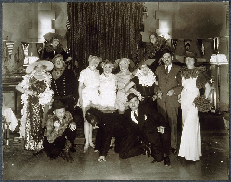 File:Thirteen men and women costumed as- the three little pigs; the "big bad" wolf; a cowboy; and a train conductor. A large model ship in on the left side of the room and a piano is on the right. (15048269553).jpg