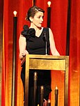 Tina Fey behind a podium.