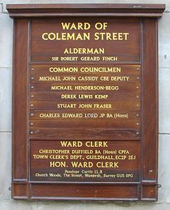A wooden notice board (each ward has at least one) displaying the Alderman, the Common Councilmen (one of whom is the Alderman's Deputy), and the clerks of that ward. Ward Coleman Street board London.jpg