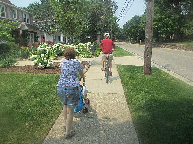 File:Woman pushing stroller, man on bike.JPG
