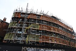 An overview of extensive renovations on the listed 34-35 Whitefriargate, an art-deco former Burton's store in Kingston upon Hull. Windows have now been installed and a combination of golden and black cladding, all in the style of the original building, are starting to appear underneath the scaffold.