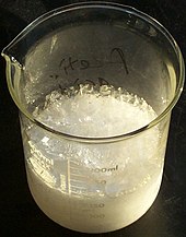 glass beaker of crystallised acetic acid