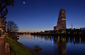 Basel - Roche-Turm mit Stadtansicht bei Abenddämmerung