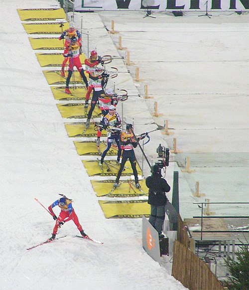 Biathletes in the shooting area of a competition
