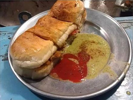 A typical bun kabab with ketchup and chutney