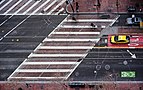 Vista aérea de uma faixa de pedestres cruzando uma rua em um ângulo inclinado, marcado com linhas paralelas brancas simples, em São Francisco