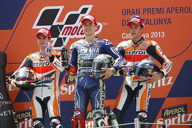 Dani Pedrosa, Jorge Lorenzo and Marc Márquez, celebrating on the podium after finishing in second, first and third in the MotoGP race.