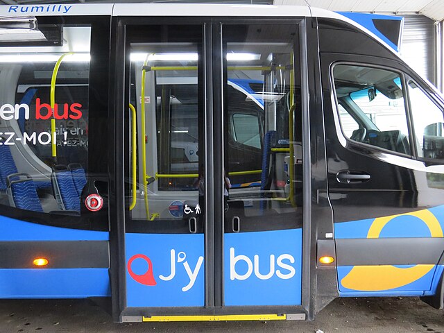 Photographie en couleurs des portes coulissantes fermées d'un minibus bleu et noir.