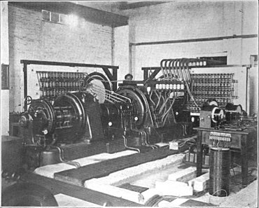 100 kW Goldschmidt alternator at Eilvese, Germany. The 250 HP DC electric motor (right), turned the 3 ft. diameter, 5 ton rotor (center), at 4000 RPM. The rotor had 360 poles, and the fundamental frequency of the alternator was 24 kHz. Complicated "reflector" circuits (capacitor banks against walls) forced the machine to produce alternating current at four times this frequency, 96 kHz. The transmitter was used for transatlantic radiotelegraphy traffic, exchanging Morse code messages with a similar Goldschmidt station at Tuckerton, New Jersey, USA. During World War I it was Germany's main communication channel to the outside world, and was used for diplomatic negotiations between Woodrow Wilson and Kaiser Wilhelm II leading to the Armistice. Eilvese Goldschmidt alternator.jpg