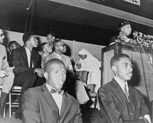 Ali (seen in background) at an address by Elijah Muhammad in 1964 Elijah Muhammad and Cassius Clay NYWTS.jpg