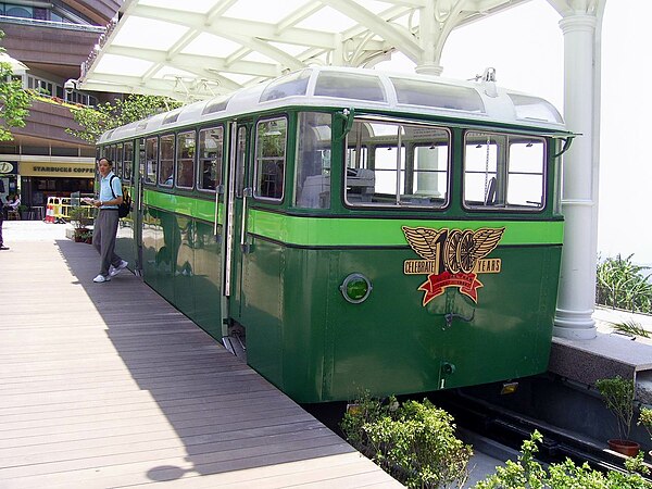 A Peak Tram car from 1956, now displayed near the upper terminus, and still carrying a headboard celebrating the line's centenary in 1988