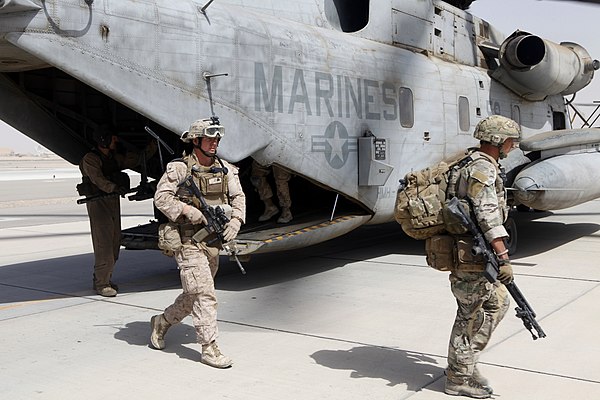 An SFSG member and a US Marine disembarking from a CH-53 Sea Stallion after a joint operation in Helmand Province 31 August 2013