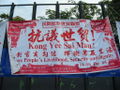 A "Kong Yee Sai Mau" (Anti-WTO) banner in Victoria Park.