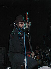 Les Claypool playing an EUB. The bow, held in a quiver, can be seen waiting for use. Les Claypool.JPG