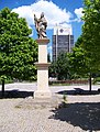 Čeština: Most, okres Most. 2. náměstí, socha svatého Prokopa, v pozadí budova SHD Komes. English: Most, Most District, Ústí nad Labem Region, Czech Republic. 2. náměstí, statue of Saint Procopius, SHD Komes building on the background. Camera location 50° 30′ 14.2″ N, 13° 38′ 32.2″ E    View all coordinates using: OpenStreetMap