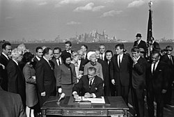 President Lyndon B. Johnson signs the Immigration Act of 1965 as Sen. Edward Kennedy, Sen. Robert Kennedy, and others look on. President Lyndon B. Johnson Signing of the Immigration Act of 1965 (02) - restoration1.jpg