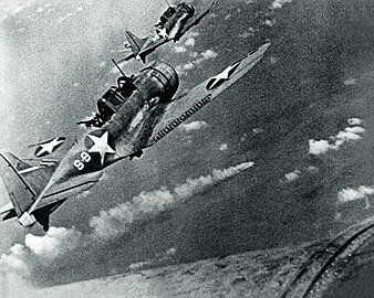 Dauntless duikbommenwerpers van de Hornet vliegen over de brandende Mikuma voor een derde aanval.