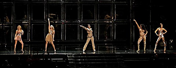 The group during The Return of the Spice Girls Tour performing "Say You'll Be There", dressed in Roberto Cavalli's bronze and copper coloured outfits