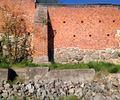 Reste der Mauer mit Sockel aus Feld- und Mauer aus Backsteinen.