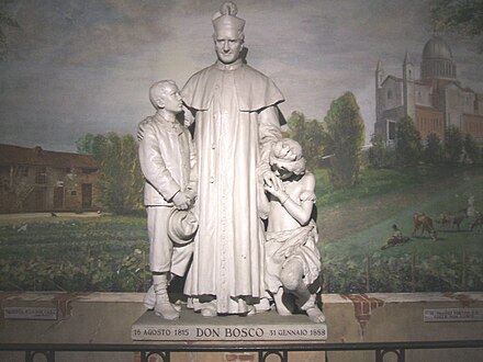 Giovanni Bosco con due giovani allievi: scultura nella sede della congregazione a Valdocco