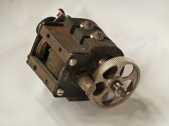 Telephone magneto viewed from beneath shows the armature (inset, left) and the horseshoe field magnets, and the gears to drive the rotor Telephone magneto from beneath.jpg