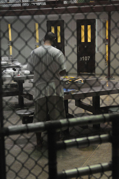File:US Navy 100330-N-7456N-028 A detainee looks through a stack of magazines at Joint Task Force (JTF) Guantanamo.jpg